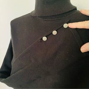 Black turtleneck
Light sweater 
Buttoned details on wrist